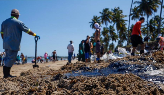 Petróleo crú sendo recolhido na praia