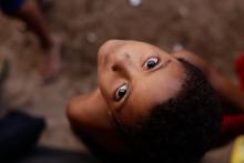 Criança negra olha pra cima, diretamente para a câmera. Foto:Leo Motta/PCR