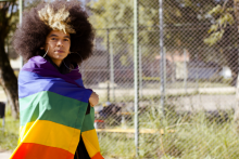 Ativista envolta em bandeira da Diversidade. Foto: Tem que Ter 